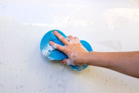 close up of hand washing a car with sponge and soapの写真素材