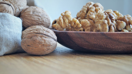 Walnuts in a wooden bowl on a wooden background. close-upの写真素材