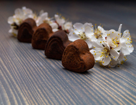 Chocolate hearts with apricot flowers on a wooden background.の写真素材