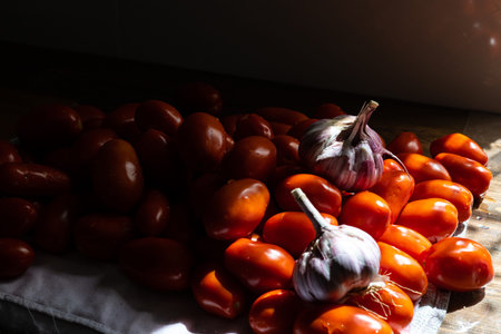 Fresh tomatoes and garlic on a wooden table in the kitchen. selective focus.の写真素材