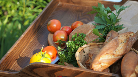 Fresh food in a wooden basket on the table in the garden.の写真素材