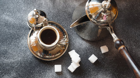 Coffee in a copper cup and sugar cubes on a dark backgroundの写真素材