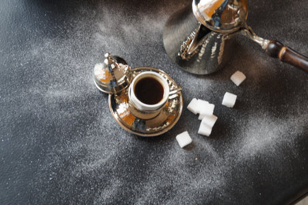 Turkish coffee in turkish coffee pot and sugar cubes on dark backgroundの写真素材