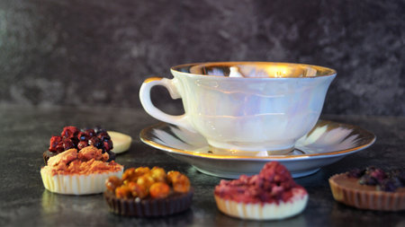 Cup of tea with berries and muffins on a dark backgroundの写真素材