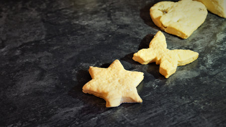 Homemade shortbread cookies with star shapes on a dark background.の写真素材