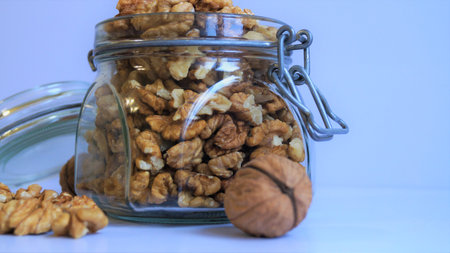 Walnuts in a glass jar on a white background. Selective focus.の写真素材