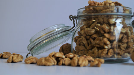 Walnuts in a glass jar on a white background. Walnut kernels.の写真素材