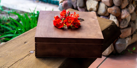 Wooden box with red flowers on a table in the garden.の写真素材