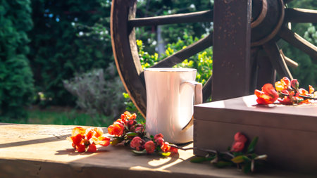 Coffee cup and flowers on the wooden table in the gardenの写真素材