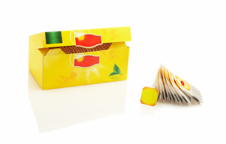 Tea bags packed in a yellow box. Isolated on white backgroundの写真素材