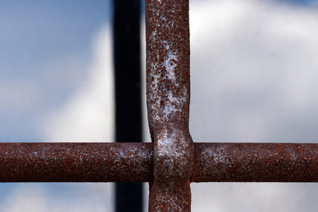 Rusting window rods and their reflection along with the reflection of white cloud in the window glassの写真素材