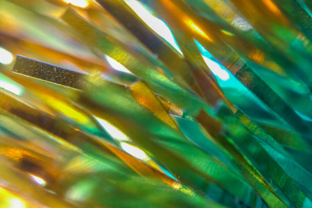 Green and gold blurred tinsel, Christmas decorations closeup, abstract background or texture