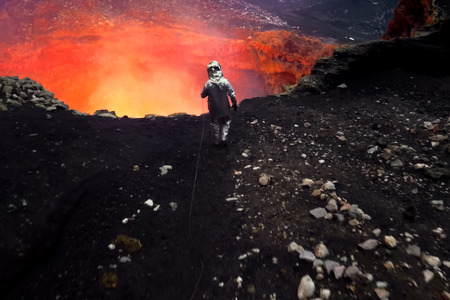 A man in a protective suit near the mouth of the volcano. Investigation of the volcano.の写真素材