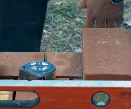 Measuring and marking bricks during the construction of the house.