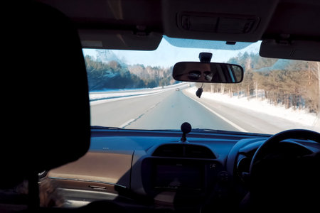 View into the windshield of a car from the passenger compartment. winter track in the forest.