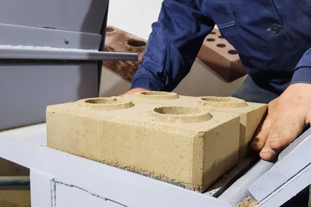 Brick making by hand pressing in a clamping mechanism.