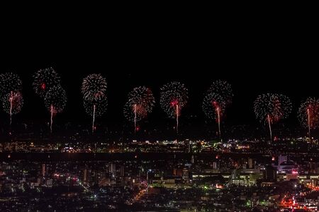 Festive salute in the night sky. Salute over the city the megalopolis. Explosions of fireworks.の写真素材