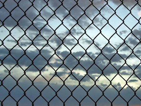 Chainlink fence with sunset viewの写真素材