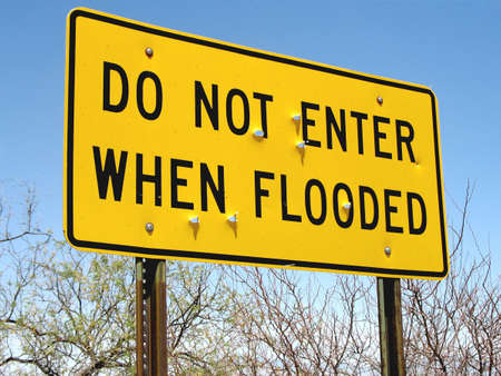 Vandalized Do Not Enter When Flooded Signの写真素材