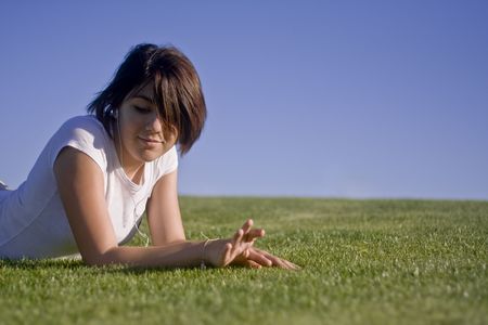 Teenage girl listening to music in the grassの写真素材