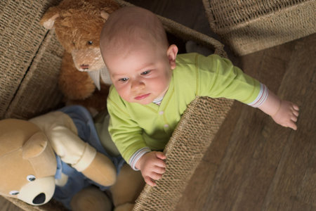 A very cute 8-9 months old baby is playing with teddy bears in a basket.  This is a full series of...