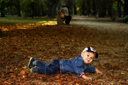 and mother are playing together with fallen leaves.の写真素材