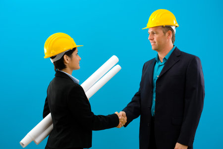 Arhitects shaking hands isolated on blue background.