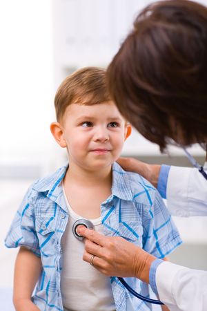 Senior female doctor examining little child boy.の写真素材