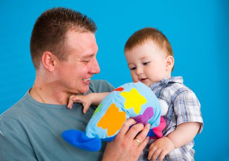Young father carrying happy baby boy ( 1 year old ) at home, smiling.の写真素材