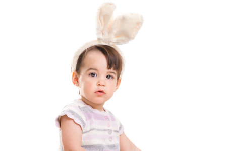 Closeup portrait of baby girl with bunny ears headband, isolated on white background.