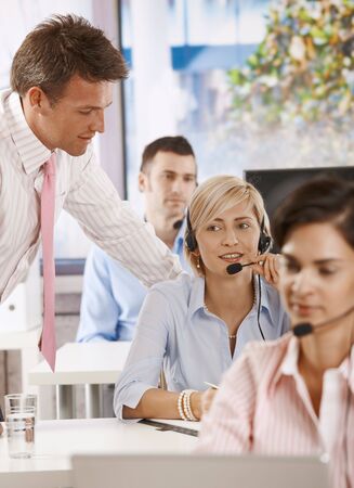 Helpdesk operators working in team in office.の写真素材