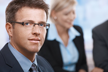 Portrait of confident mid-adult businessman looking at camera office. 