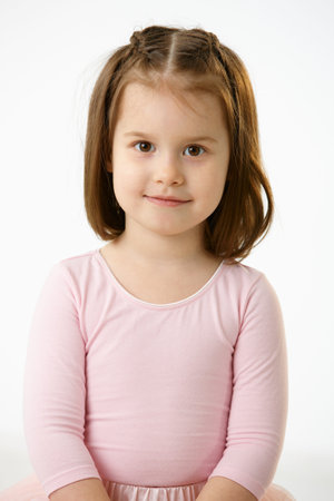 Portrait of smiling little girl in pink dress over white background.の写真素材