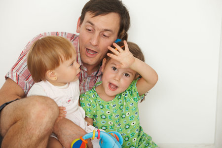 Portrait of happy father with two daughters having fun.の写真素材