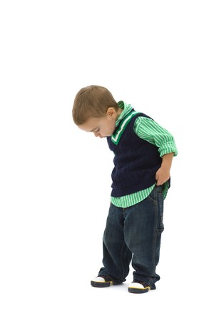 Portrait of preschoold boy posing green shirt and jeans, looking down, isolated on white.の写真素材