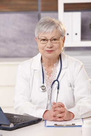 Portrait of medical expert at work, looking at camera, smiling.の写真素材