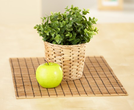 Green apple and plant put on tableの写真素材