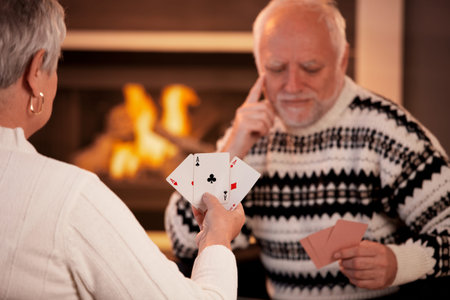 Senior couple playing cards, focus on cards handheld by woman, three ace.の写真素材
