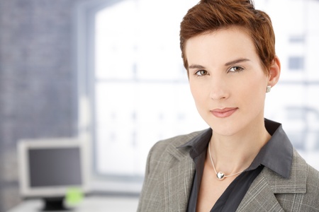 Portrait of smart businesswoman in office, smiling at camera.の写真素材