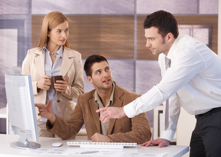 Young colleagues teamworking in office, having discussion. Young colleagues teamworking in office, having discussion.