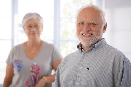 Portrait of happily smiling old man, woman in the background.の写真素材