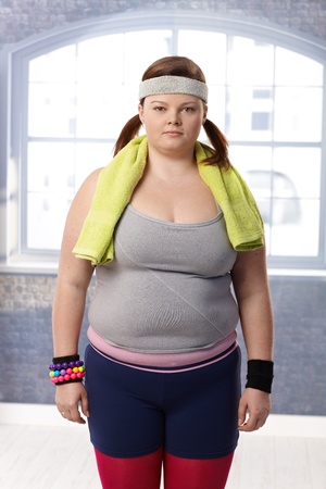 Fat woman standing at the gym in sportswear prepared for doing gymnastics.の写真素材