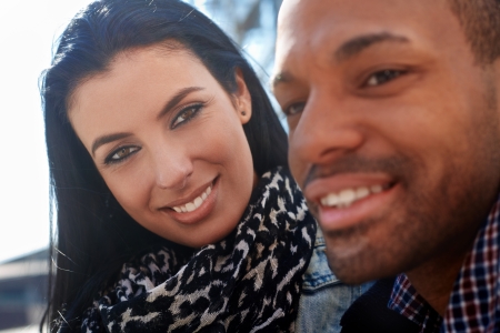 Outdoor portrait of young couple. Focus on woman looking to man, smiling.の写真素材