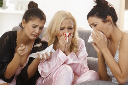 Portrait of three crying women at home, sharing sorrow, wearing pyjamas.の写真素材