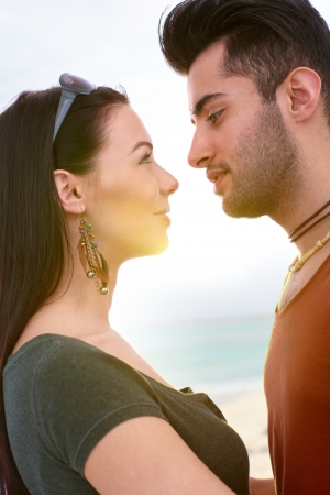 Young loving couple kissing on the beach, side view.の写真素材