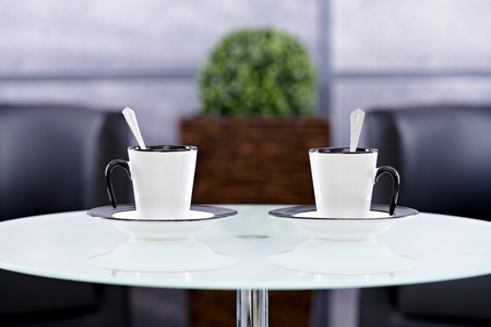 Closeup photo of two stylish coffee cups on a round table.の写真素材