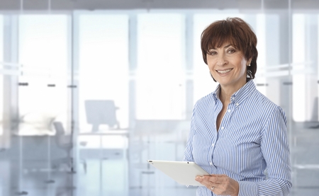Mid-adult businesswoman using tablet computer at office.の写真素材