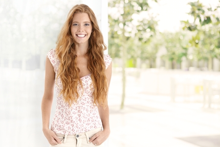 Summer portrait of long hair gingerish woman, smiling happy, looking at camera. Plenty of copyspace.の写真素材