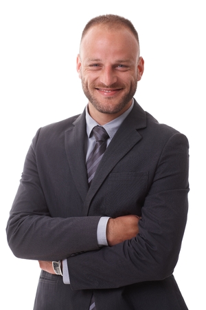 Portrait of happy businessman standing arms, smiling, looking at camera.の写真素材