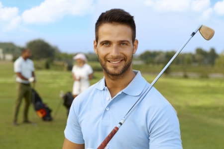 Closeup portrait of handsome young male golfer with golf club.の写真素材